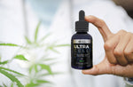 Doctor holding UltraCell CBD Oil near CBD hemp plant for pain relief by Zilis & ultraZwell